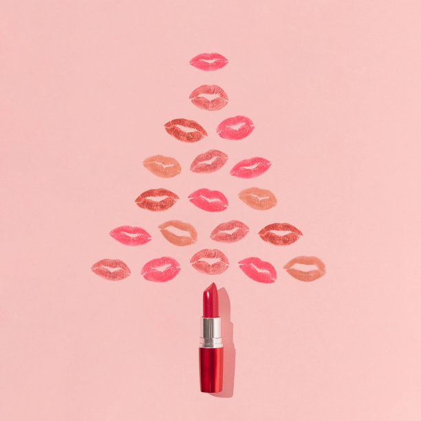 用口红和鲜艳的唇印做成的圣诞树形状。最小的新年美容概念。创造性的化妆或化妆品美学。假日吻模式。图片下载