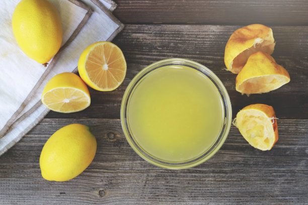 新鲜挤柠檬汁在一个小碗里。前视图。图片下载