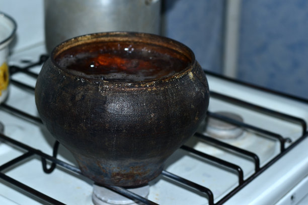 一个古董锅，炉子上放着蔬菜。图片下载