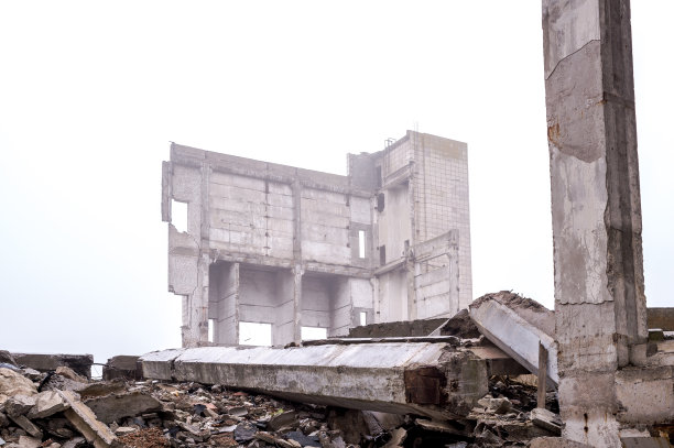 混凝土碎片和混凝土梁的废墟背景的建筑和灰色的天空在朦胧的阴霾。背景图片下载