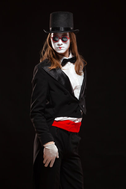 男哑剧艺术家的肖像表演，孤立在黑色的背景。男人站得笔直，手放在肚子上图片下载