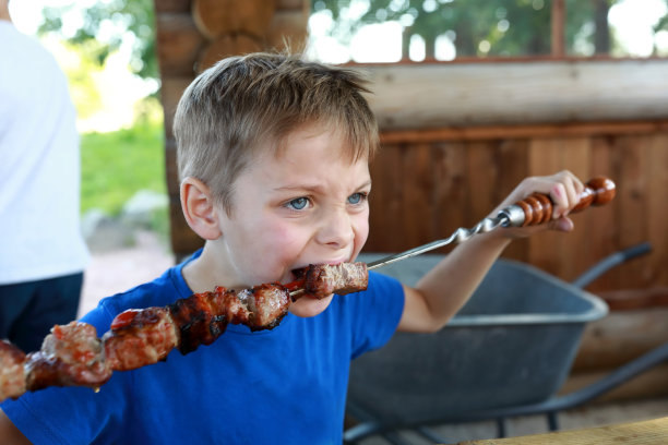 男孩吃串猪肉图片下载