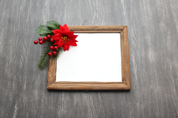 照片框围绕一品红花，藤条和风车作为圣诞祈祷的圣诞信息图片下载