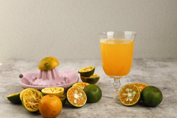 新鲜压扁的橙汁(在印度尼西亚叫Jeruk Peras)放在棕色水泥桌上的杯子上图片下载