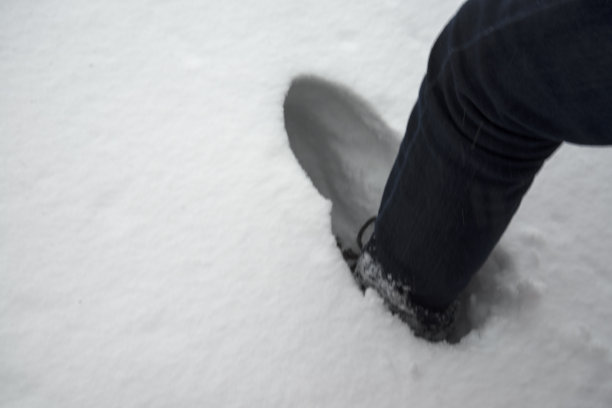 一个人的脚踩进了雪堆图片下载