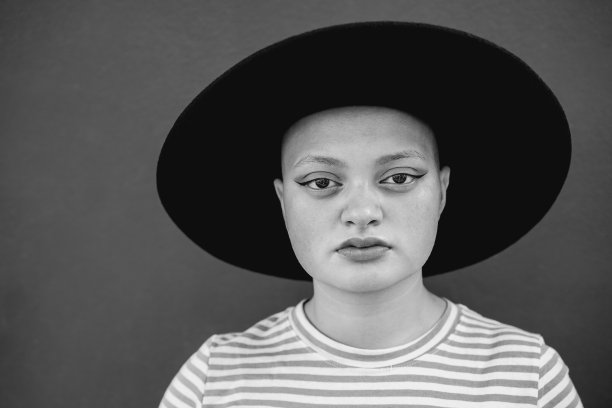 嬉皮士秃头女孩看着严肃的相机室外-焦点在脸-黑白编辑图片下载