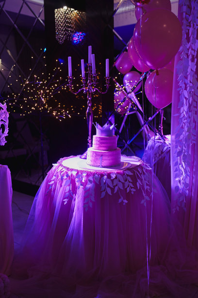 第一个生日公主蛋糕，头顶皇冠，背景是粉色气球。1岁儿童节日糖果棒。小女孩一岁生日派对。有选择性的重点图片下载