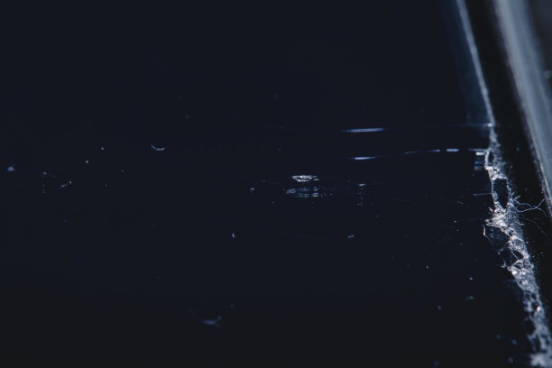 一个破碎的智能手机屏幕上的裂痕。手机保护膜损坏。照片在软焦点在高倍放大。图片下载