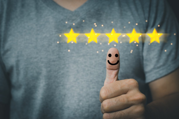 商人竖起大拇指按下笑脸按钮，获得最佳评价和优秀的客户评分。客户满意度的概念图片下载