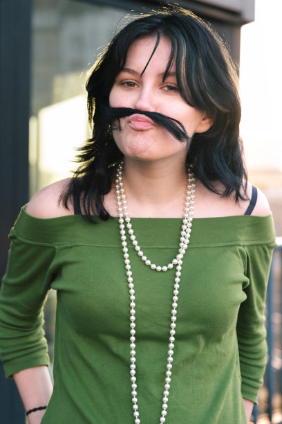 一个十几岁的女孩用她的头发做了一个小胡子图片下载