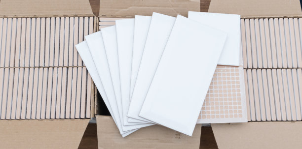 在三个装有修理材料的盒子的背景上，有一块白色瓷砖的样品，上面有铭文的地方图片下载