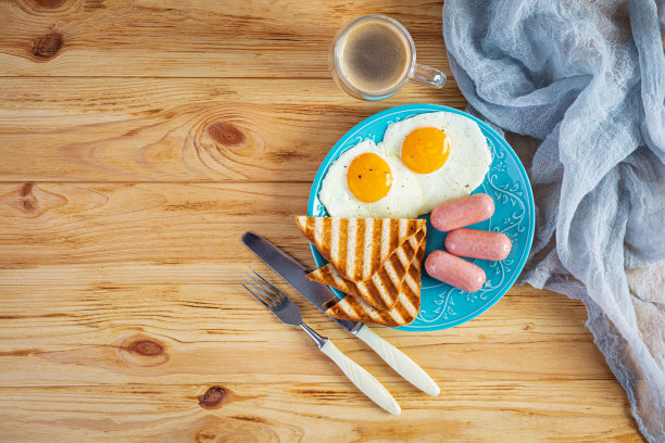 美味的早餐有鸡蛋、香肠、烤面包和一杯咖啡。美国的早餐。俯视图图片下载