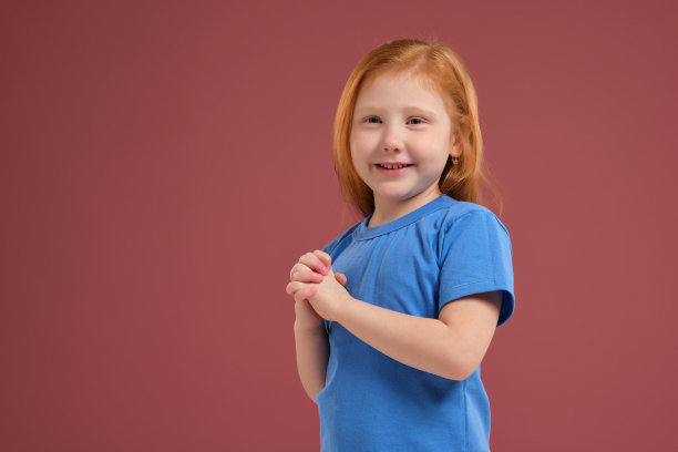 可爱的红发情感小女孩的肖像在红色的背景图片下载