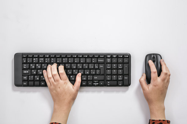 女性的双手使用白色背景上的键盘和鼠标。图片下载