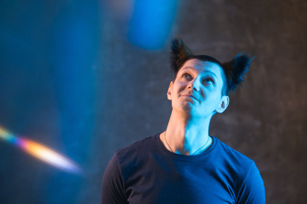 成年男子与彩色霓虹灯在黑暗的背景。图片下载