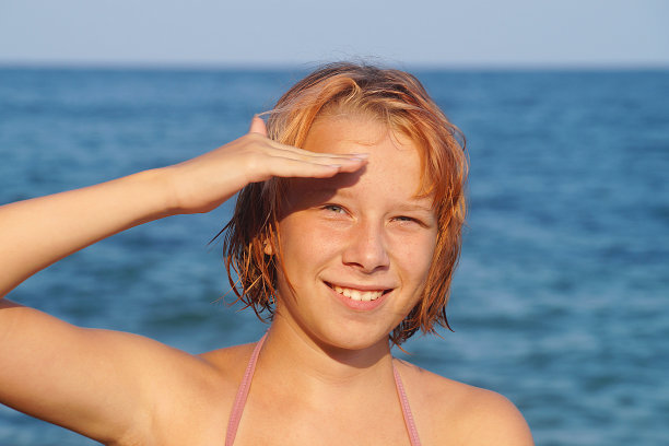 以海平面为背景的微笑红发少女的画像图片下载