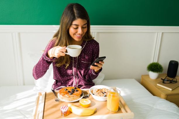 快乐的女人在卧室里享受一杯咖啡图片下载
