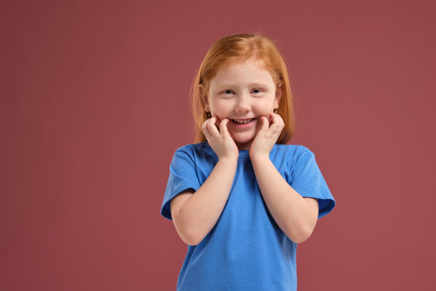可爱的红发情感小女孩的肖像在红色的背景图片下载