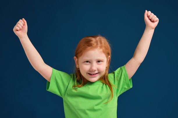 特写照片的小红发情绪女孩在相机前摆在蓝色的背景图片下载