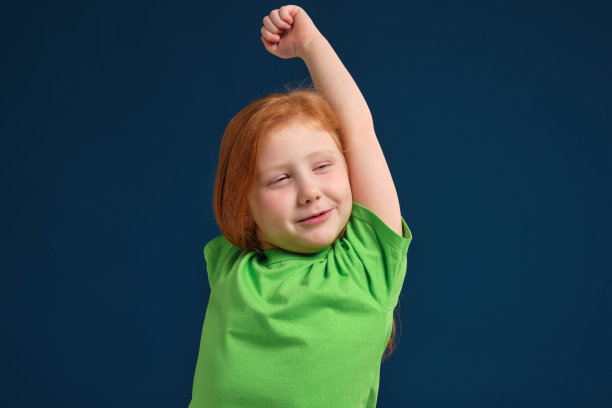 特写照片的小红发情绪女孩在相机前摆在蓝色的背景图片下载