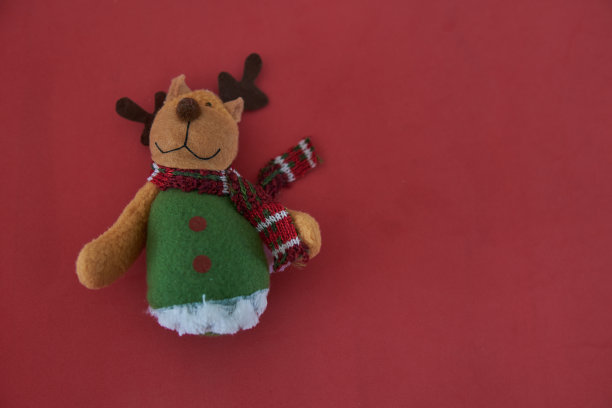 红色背景上可爱的驯鹿圣诞装饰品。水平的明信片。本空间图片下载