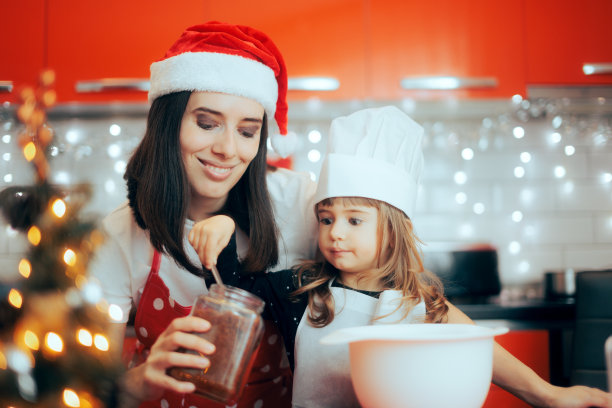 小女孩从罐子里拿糖和妈妈一起烘焙图片下载