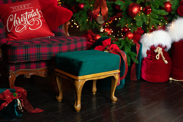 时尚的格子扶手椅与绿色蓬松。舒适的扶手椅与奥斯曼在室内房间。在圣诞树附近装着礼物的红色圣诞老人。装饰漂亮的客厅，为圣诞节准备的。斯堪的纳维亚风格图片下载