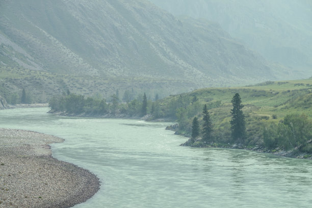 雾蒙蒙的山景，山河宽阔。深绿幽幽的景色，大山河在雾中。在阴雨天气，看到大山之间的大河。图片下载