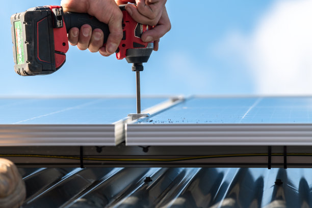 不明身份男子将太阳能电池板安装到车顶架上图片下载