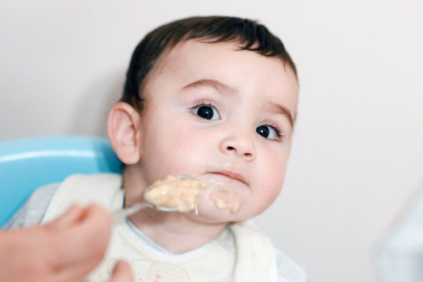 母亲用汤匙喂婴儿食物图片下载