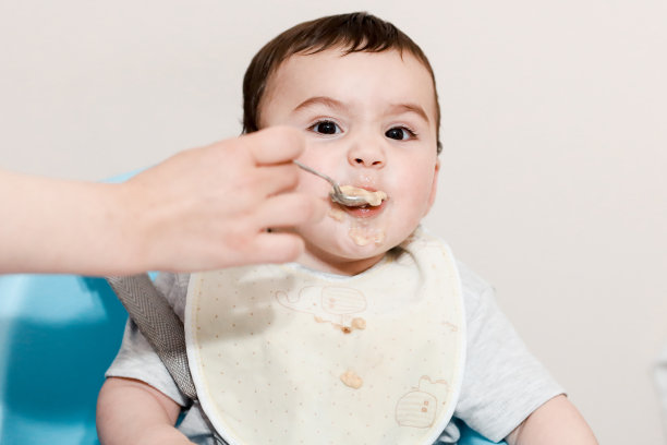 母亲用汤匙喂婴儿食物图片下载
