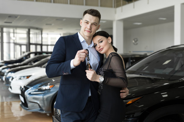 几个男人和女人很高兴在汽车经销店买一辆新车图片下载