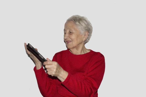 带着平板电脑微笑的高级女性。孤立在白色图片下载