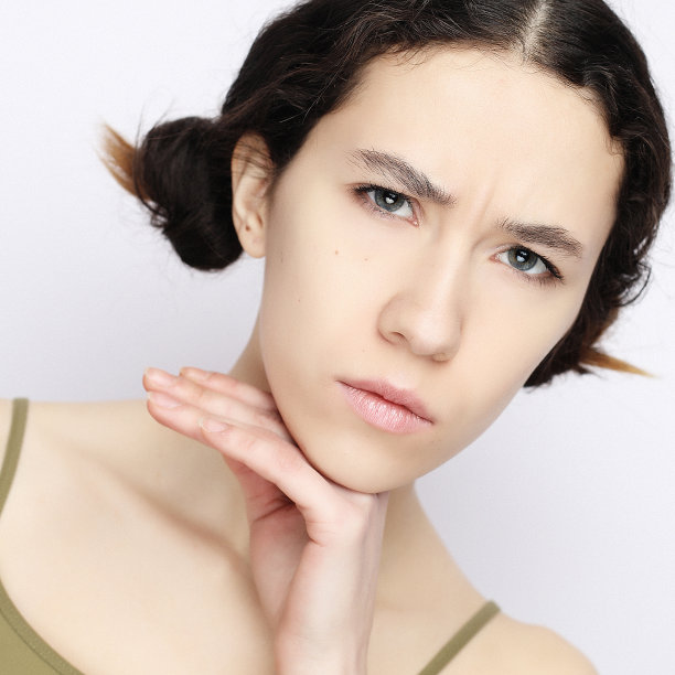 一个兴高采烈的年轻女孩在白色背景下看着照相机图片下载