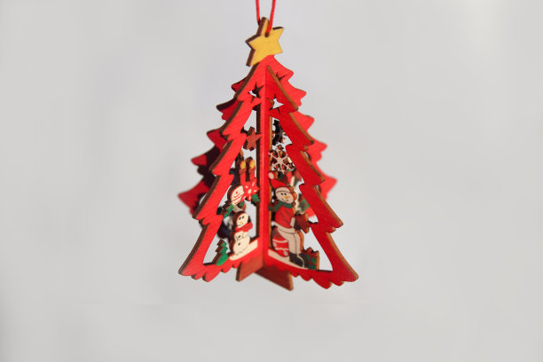 圣诞玩具。木制小模型冬季松树与黄色的星孤立在白色的背景。圣诞树上挂着。贺卡。副本的空间。白色背景。节日的概念图片下载