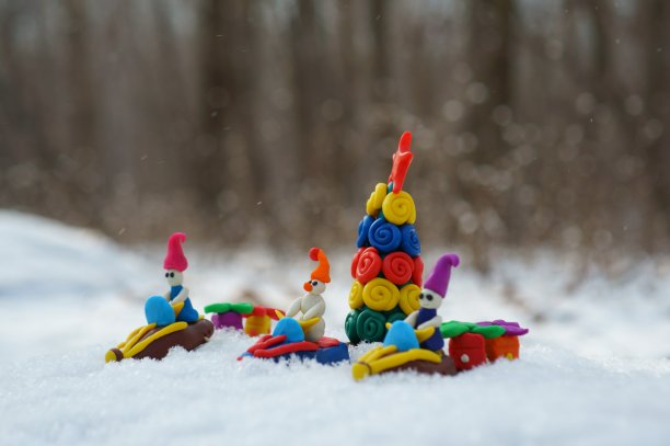 圣诞人物坐在由橡皮泥制成的雪地摩托上，载着圣诞树和礼物。图片下载