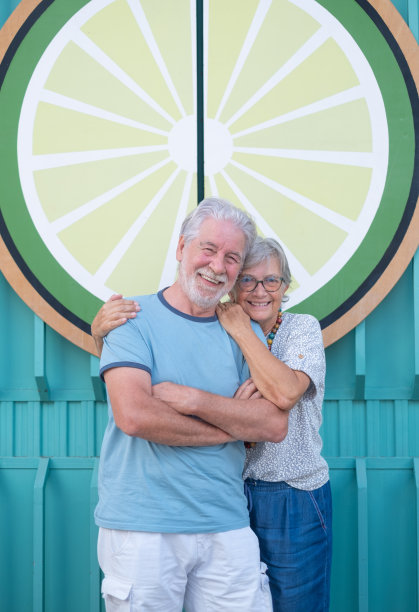 可爱的老夫妇拥抱微笑站在户外看着相机。年轻夫妇享受退休生活图片下载