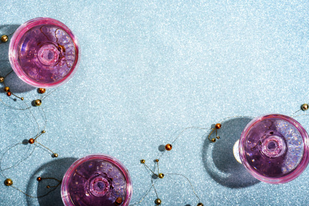 粉色香槟在水晶杯在闪亮的薄荷模糊的背景。新年庆祝会与少女魅力饮料。夜总会聚会，为时髦和优雅的女孩。图片下载