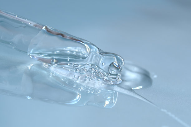 蓝色单色背景下透明质酸液吸管。化妆品和保健概念特写图片下载