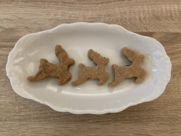 三个驯鹿圣诞饼干放在一个白色盘子里图片下载
