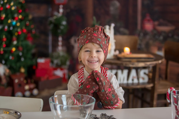 可爱的金发小孩，蹒跚学步的男孩，在家烤圣诞饼干图片下载