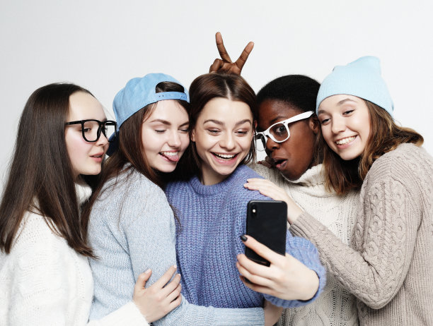 五个不同国家的女孩穿着便装，用智能手机自拍图片下载