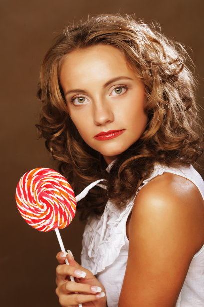 美女卷女孩肖像捧着彩色棒棒糖图片下载