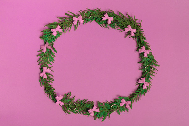 以冷杉树枝和粉红色背景装饰的圣诞花环。平铺，俯视图，复制空间。节日的作文图片下载