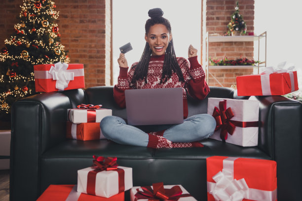 疯狂的照片购物狂女士持有笔记本电脑信用卡在线零售概念穿套头衫在室内装饰的家图片下载