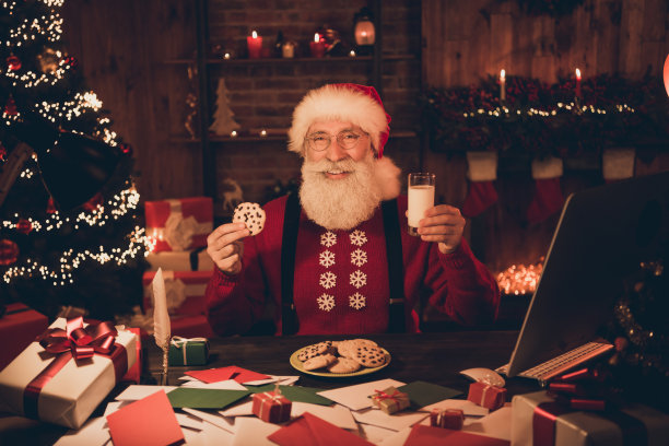 照片肖像快乐微笑的圣诞老人戴眼镜头饰毛衣微笑吃饼干喝牛奶图片下载