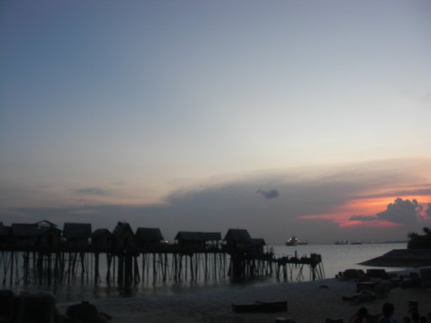 海滩边棚屋的剪影图片下载