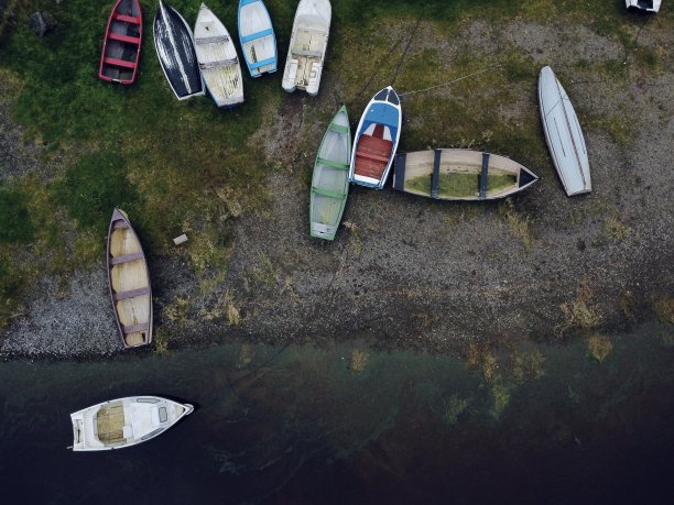 航拍照片，废弃的船只和独木舟在满是树木的湖周围图片下载