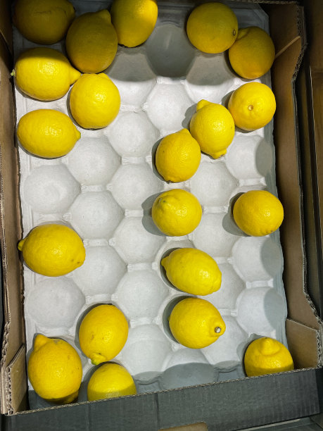 超市蔬果区出售的黄柠檬，空隔间的纸箱，盒子里的柑橘，高架的视野图片下载