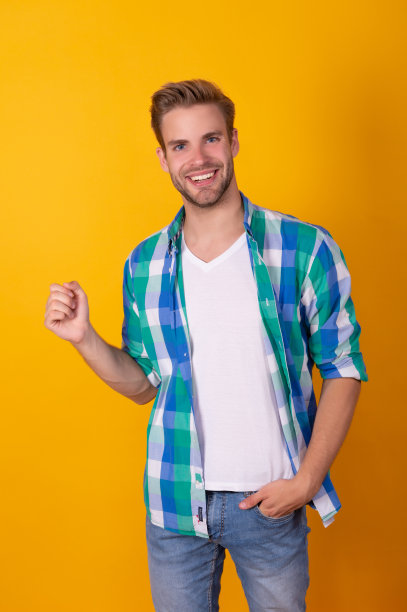 快乐的帅哥穿着格子衬衫假装拿着什么黄色的背景复制空间，广告图片下载